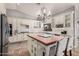 A bright kitchen with stone floors, white cabinets, large island, and a chandelier at 21666 N 53Rd Dr, Glendale, AZ 85308