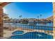 Balcony view of a private pool, waterfront homes, and lush landscaping alongside a serene canal at 21666 N 53Rd Dr, Glendale, AZ 85308