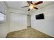 Bedroom features a ceiling fan, carpeted floors, a closet, and a TV on the wall at 240 S Old Litchfield Rd # 206, Litchfield Park, AZ 85340