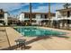 Community pool surrounded by condos with shaded seating areas and lush landscaping at 240 S Old Litchfield Rd # 206, Litchfield Park, AZ 85340