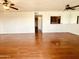 Spacious living room featuring ceiling fans, wood floors, and a view into the kitchen at 240 S Old Litchfield Rd # 208, Litchfield Park, AZ 85340