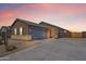 Charming single-story home with desert landscaping, stone accents, and a spacious driveway under a colorful sunset sky at 2466 E Rosario Mission Dr, Casa Grande, AZ 85194