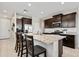 Modern kitchen featuring dark wood cabinets, stainless steel appliances, granite countertops and a large island with seating at 2466 E Rosario Mission Dr, Casa Grande, AZ 85194