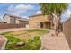 Backyard featuring grass, gravel, a block wall, desert landscaping, and a covered patio at 2551 E Kent Ave, Gilbert, AZ 85296