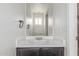 Bathroom featuring a dark wood vanity with white countertop, oval sink, and modern fixtures at 2551 E Kent Ave, Gilbert, AZ 85296