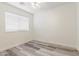 This bedroom features a ceiling fan, wood-look flooring, and bright natural light from the window at 2551 E Kent Ave, Gilbert, AZ 85296