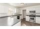 Bright kitchen with stainless steel appliances, grey countertops, white cabinetry, and dark wood-look floors at 2551 E Kent Ave, Gilbert, AZ 85296