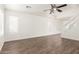 Spacious living room featuring wood-look flooring, a ceiling fan, and a staircase with glass at 2551 E Kent Ave, Gilbert, AZ 85296