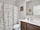 Clean bathroom with a vanity, decorative mirror and shower with printed curtain at 25601 W Coles Rd, Buckeye, AZ 85326