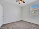 A carpeted bedroom features a window that lets in plenty of natural light and a ceiling fan for optimal temperature control at 25601 W Coles Rd, Buckeye, AZ 85326