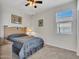 Comfortable bedroom with natural light, a ceiling fan, and light, neutral carpet at 25601 W Coles Rd, Buckeye, AZ 85326