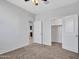 A bedroom features neutral walls, a ceiling fan, and access to a walk-in closet and an adjacent room at 25601 W Coles Rd, Buckeye, AZ 85326