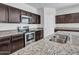 Bright kitchen featuring granite countertops, stainless steel appliances, and dark cabinets at 25601 W Coles Rd, Buckeye, AZ 85326