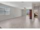 Bright living room featuring neutral tile floors, large window, and ceiling fan at 25601 W Coles Rd, Buckeye, AZ 85326