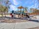 A brightly colored playground has climbing features, slides, and soft, padded ground at 25601 W Coles Rd, Buckeye, AZ 85326