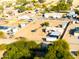 Aerial view of a property featuring multiple buildings, a large dirt lot and mature trees at 26631 S Lime Dr, Queen Creek, AZ 85142