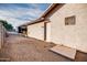 Side yard with gravel, shed, and door to stucco house at 26631 S Lime Dr, Queen Creek, AZ 85142