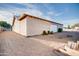 Back exterior featuring a detached garage, gravel yard, desert landscaping, and sunny blue sky at 26631 S Lime Dr, Queen Creek, AZ 85142