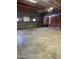 Spacious garage interior featuring gray concrete block walls, concrete flooring, and exposed ceiling structure at 2721 W Rose Ln, Phoenix, AZ 85017