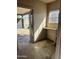 View of sunlit hallway with worn flooring, window and a shelving area, that leads to an outdoor space at 2721 W Rose Ln, Phoenix, AZ 85017