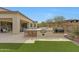 Outdoor kitchen complete with a built-in grill and bar seating overlooks the lush green yard at 29348 N Clear Ridge Rd, Rio Verde, AZ 85263