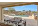 Outdoor patio with travertine tile, a dining area, and a pool with desert landscape views at 29348 N Clear Ridge Rd, Rio Verde, AZ 85263