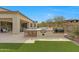 Outdoor kitchen complete with a built-in grill and bar seating overlooks the lush green yard at 29348 N Clear Ridge Rd, Rio Verde, AZ 85263