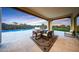 Covered patio with travertine tile, a dining area, and views of the pool and desert landscape at 29348 N Clear Ridge Rd, Rio Verde, AZ 85263