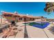 Exterior view of the home showcasing a backyard pool with diving board and seating areas at 3279 E Selma Hwy, Casa Grande, AZ 85194