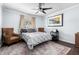 Modern bedroom featuring a bed, ceiling fan, two chairs, and warm wooden floors at 3279 E Selma Hwy, Casa Grande, AZ 85194