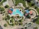 An aerial view of a resort-style community pool with slides, splash pads, lounge seating, and shade structures at 335 S Saint Augustine Ct, Casa Grande, AZ 85194