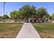 Community playground featuring slides and a walking path surrounded by mature trees and green space at 335 S Saint Augustine Ct, Casa Grande, AZ 85194