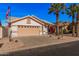 Charming single-story home featuring a two-car garage, desert landscaping, and mature palm trees at 3354 N 157Th Ave, Goodyear, AZ 85395