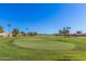 Well-manicured green with mature trees and clear blue sky on golf course at 3354 N 157Th Ave, Goodyear, AZ 85395