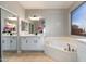 A bathroom features white cabinets and a large soaking tub near a window at 3416 E Blue Ridge Pl, Chandler, AZ 85249