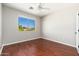 Empty bedroom with hardwood floors, ceiling fan, and view of the landscape at 3416 E Blue Ridge Pl, Chandler, AZ 85249