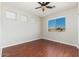 Bright bedroom featuring wood floors, a ceiling fan, and a window with a view at 3416 E Blue Ridge Pl, Chandler, AZ 85249