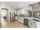 Bright kitchen featuring stainless steel appliances, white cabinetry and a view of the staircase at 3416 E Blue Ridge Pl, Chandler, AZ 85249