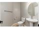 Powder room with pedestal sink, a round mirror and a toilet at 3416 E Blue Ridge Pl, Chandler, AZ 85249