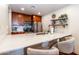 Kitchen featuring wooden cabinetry, stainless steel appliances and a marble countertop bar with seating at 36601 N Mule Train Rd # D30, Carefree, AZ 85377