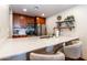 Kitchen featuring wooden cabinetry, stainless steel appliances and a marble countertop bar with seating at 36601 N Mule Train Rd # D30, Carefree, AZ 85377