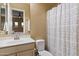 Neutral bathroom features a shower-tub combo with patterned curtain and a vanity with mirror at 37080 N 109Th Way, Scottsdale, AZ 85262