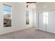 Bright bedroom features neutral carpet, ample natural light from two windows, and a ceiling fan at 37080 N 109Th Way, Scottsdale, AZ 85262