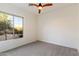 Bright bedroom features neutral carpet, ample natural light from the large window, and a ceiling fan at 37080 N 109Th Way, Scottsdale, AZ 85262