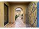 Elegant entryway featuring stone flooring and a view through an arched gate to a courtyard at 37080 N 109Th Way, Scottsdale, AZ 85262