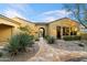 Inviting front entrance with desert landscaping, a stone pathway, and an arched gate at 37080 N 109Th Way, Scottsdale, AZ 85262