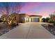 A three car garage with a long driveway framed by desert landscaping at sunset at 37080 N 109Th Way, Scottsdale, AZ 85262