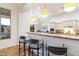 Kitchen bar area with seating, decorative lighting, granite countertops, and backyard view at 37080 N 109Th Way, Scottsdale, AZ 85262