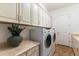 Functional laundry room with modern washer, dryer, generous cabinet space, and laminate countertops at 37080 N 109Th Way, Scottsdale, AZ 85262