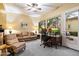 Living room with a workspace, leather seating, and a ceiling fan at 37080 N 109Th Way, Scottsdale, AZ 85262